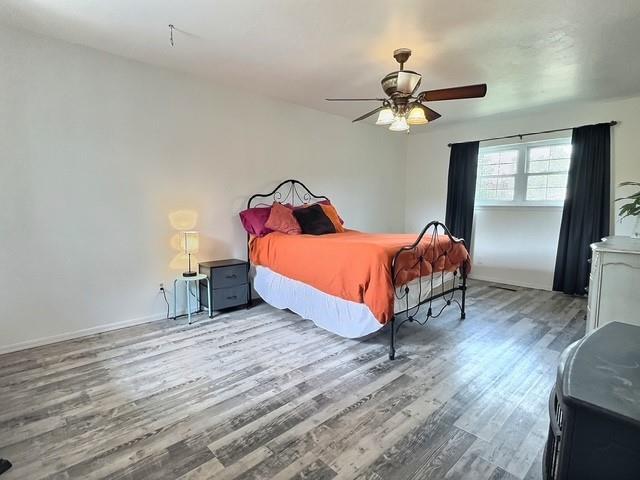 1024 E 12th St, Cushing, OK 74023 - bedroom with wood finished floors and a ceiling fan