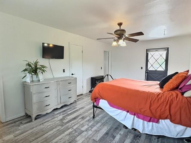 1024 E 12th St, Cushing, OK 74023 - bedroom with light wood finished floors and ceiling fan