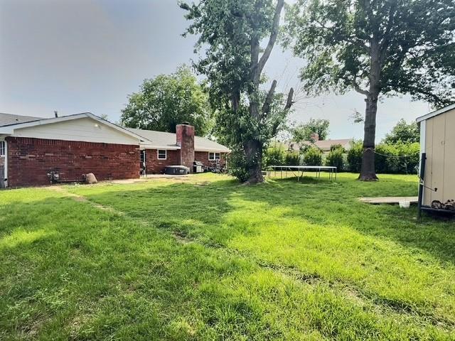 1024 E 12th St, Cushing, OK 74023 - view of green lawn with a trampoline