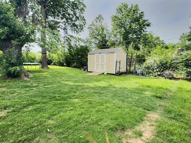 1024 E 12th St, Cushing, OK 74023 - view of grassy yard featuring a storage unit and a trampoline