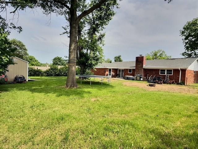 1024 E 12th St, Cushing, OK 74023 - view of grassy yard with a trampoline