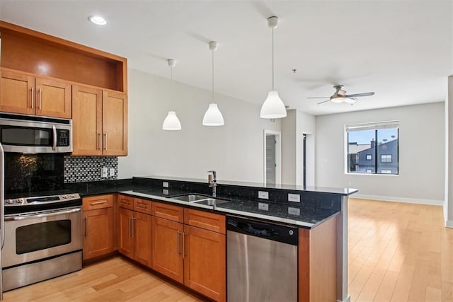 444 N Central Ave Unit 204, Oklahoma City, OK 73104 - kitchen with appliances with stainless steel finishes, a peninsula, dark stone counters, ceiling fan, and light wood-style flooring