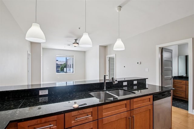 444 N Central Ave Unit 204, Oklahoma City, OK 73104 - kitchen with stainless steel dishwasher, brown cabinets, light wood-type flooring, pendant lighting, and dark stone counters