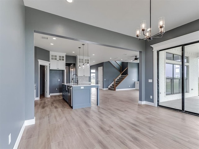 7431 NE Hawk Dr, Piedmont, OK 73078 - kitchen with open floor plan, light countertops, white cabinetry, a chandelier, and healthy amount of natural light