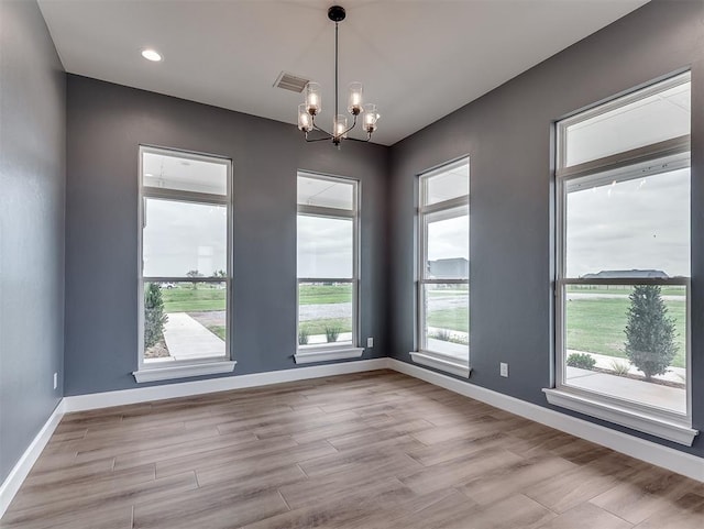 7431 NE Hawk Dr, Piedmont, OK 73078 - empty room with a chandelier and light wood finished floors
