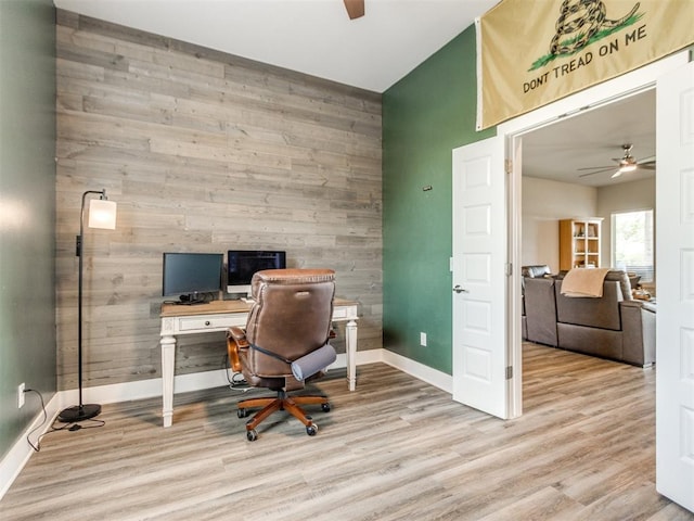 2315 Dixie Dr, Blanchard, OK 73010 - home office with wooden walls, a ceiling fan, wood finished floors, and an accent wall