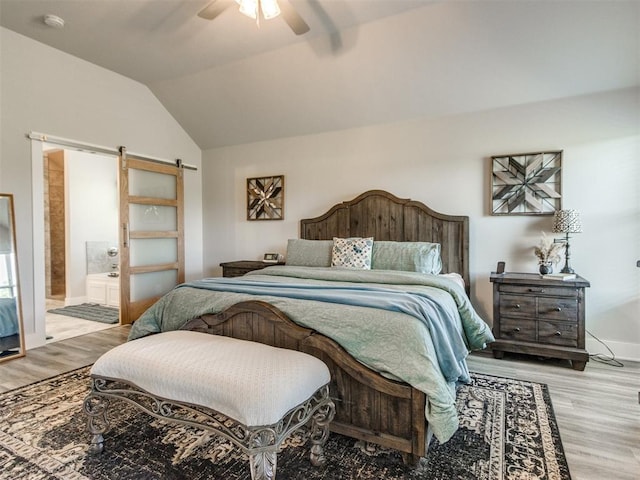 2315 Dixie Dr, Blanchard, OK 73010 - bedroom with a barn door, wood finished floors, vaulted ceiling, connected bathroom, and a ceiling fan