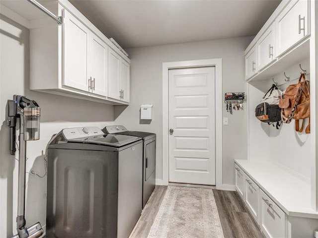 2315 Dixie Dr, Blanchard, OK 73010 - laundry area with cabinet space, washer and clothes dryer, and wood finished floors