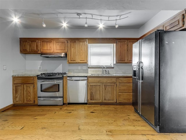 1800 Michael Dr, Edmond, OK 73013 - kitchen featuring appliances with stainless steel finishes, light wood-style floors, and brown cabinets