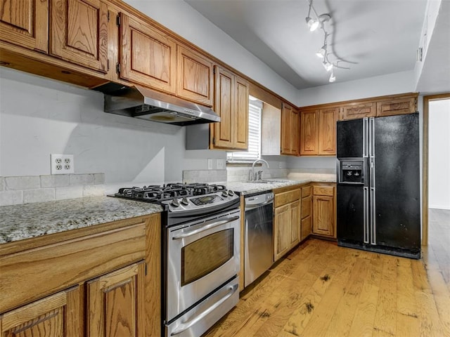 1800 Michael Dr, Edmond, OK 73013 - kitchen with stainless steel appliances, under cabinet range hood, light wood-style flooring, and brown cabinetry