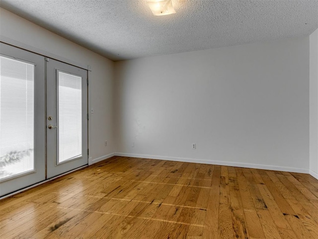 1800 Michael Dr, Edmond, OK 73013 - unfurnished room featuring french doors, a textured ceiling, and hardwood / wood-style floors