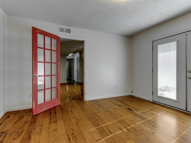 1800 Michael Dr, Edmond, OK 73013 - spare room featuring a textured ceiling and hardwood / wood-style floors