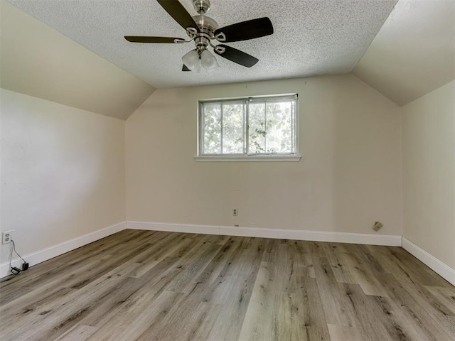 1800 Michael Dr, Edmond, OK 73013 - bonus room featuring vaulted ceiling, a ceiling fan, wood finished floors, and a textured ceiling
