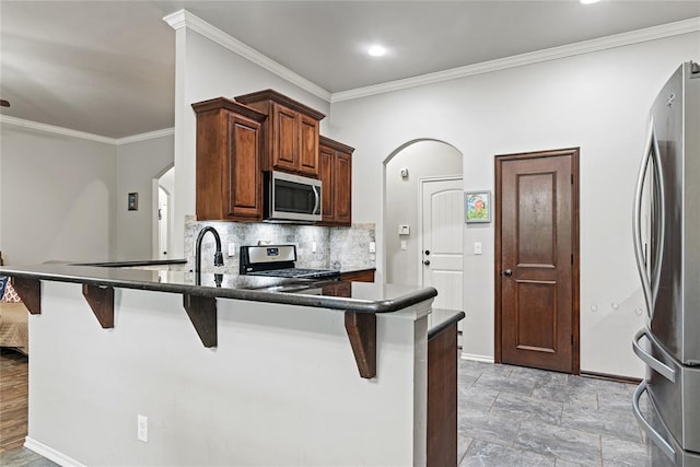 7324 Ridge Manor Ln, Oklahoma City, OK 73150 - kitchen with stainless steel appliances, ornamental molding, backsplash, a breakfast bar, and dark countertops