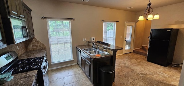 12201 Buckingham Ln, Yukon, OK 73099 - kitchen featuring stainless steel appliances, dark countertops, a peninsula, and healthy amount of natural light