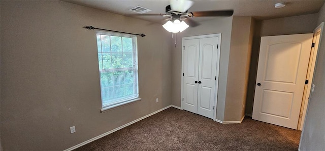 12201 Buckingham Ln, Yukon, OK 73099 - unfurnished bedroom with dark colored carpet, a closet, and a ceiling fan