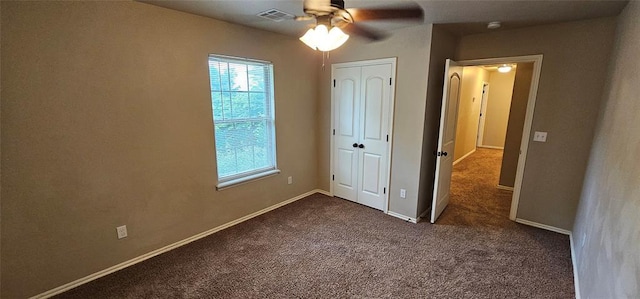 12201 Buckingham Ln, Yukon, OK 73099 - unfurnished bedroom featuring dark carpet, a closet, and a ceiling fan