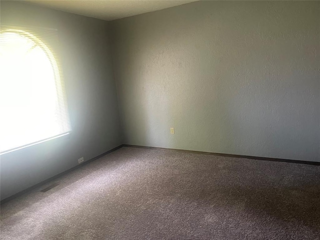 spare room with carpet and baseboards