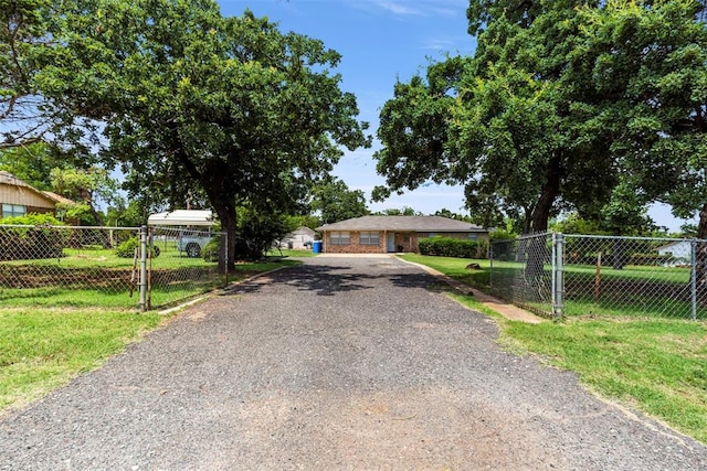 901 E Covell Rd, Edmond, OK 73034 - view of front of house featuring gravel driveway and a gate