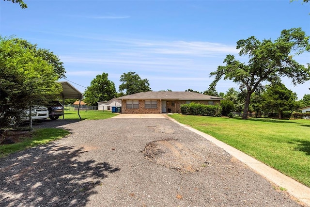 901 E Covell Rd, Edmond, OK 73034 - single story home featuring gravel driveway, brick siding, and a detached carport