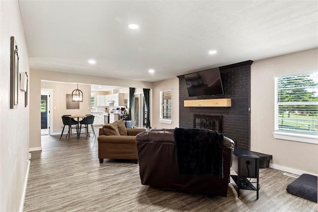 901 E Covell Rd, Edmond, OK 73034 - living room with light wood-style floors, plenty of natural light, a brick fireplace, and recessed lighting