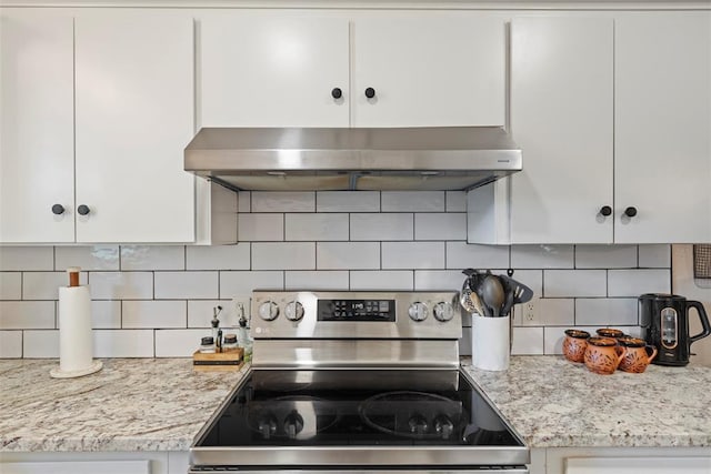 901 E Covell Rd, Edmond, OK 73034 - kitchen featuring stainless steel range with electric stovetop, wall chimney range hood, white cabinetry, and tasteful backsplash