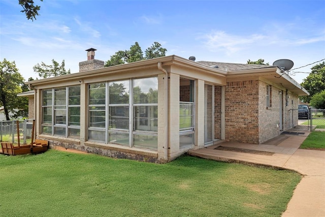 901 E Covell Rd, Edmond, OK 73034 - view of side of property with brick siding, a sunroom, and a chimney
