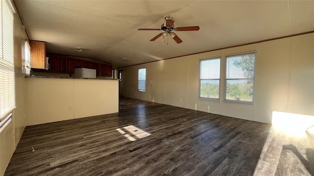 1500 S Pine Cir, Guthrie, OK 73044 - unfurnished living room featuring vaulted ceiling, ceiling fan, dark wood finished floors, and a decorative wall