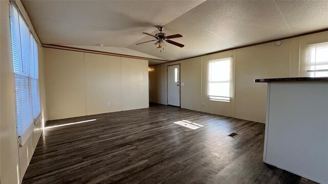1500 S Pine Cir, Guthrie, OK 73044 - unfurnished living room featuring ceiling fan, dark wood-style flooring, and vaulted ceiling