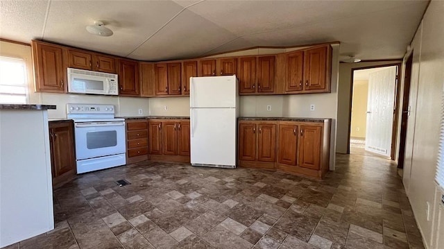 1500 S Pine Cir, Guthrie, OK 73044 - kitchen featuring white appliances, brown cabinetry, stone finish floors, and vaulted ceiling
