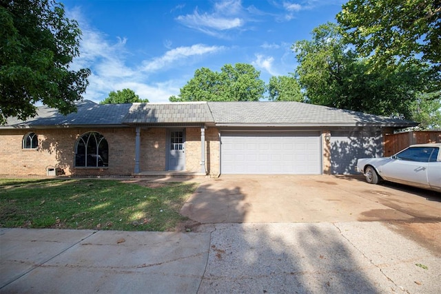 2328 NW 113th St, Oklahoma City, OK 73120 - ranch-style home featuring brick siding, a garage, concrete driveway, and a front yard