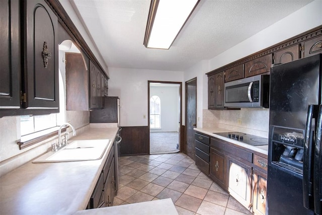 2328 NW 113th St, Oklahoma City, OK 73120 - kitchen featuring black appliances, dark brown cabinetry, light countertops, plenty of natural light, and wainscoting