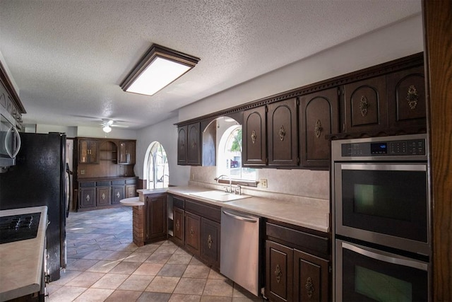 2328 NW 113th St, Oklahoma City, OK 73120 - kitchen featuring appliances with stainless steel finishes, dark brown cabinets, light countertops, a textured ceiling, and ceiling fan