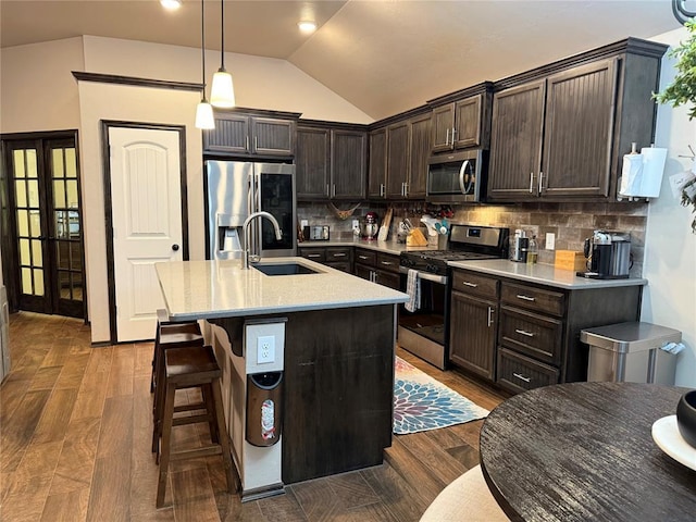 18641 Como Dr, Edmond, OK 73012 - kitchen with appliances with stainless steel finishes, dark brown cabinetry, vaulted ceiling, light countertops, and tasteful backsplash