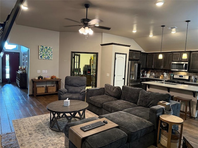 18641 Como Dr, Edmond, OK 73012 - living room featuring dark wood finished floors, ceiling fan, arched walkways, and vaulted ceiling