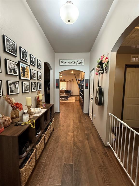 18641 Como Dr, Edmond, OK 73012 - hallway featuring arched walkways, dark wood-style floors, and stairway