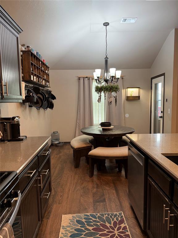 18641 Como Dr, Edmond, OK 73012 - dining area with vaulted ceiling, a chandelier, and dark wood finished floors