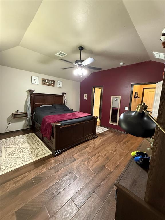 18641 Como Dr, Edmond, OK 73012 - bedroom with lofted ceiling, wood tiled floors, and a ceiling fan