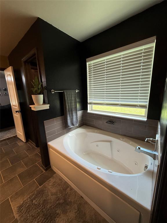18641 Como Dr, Edmond, OK 73012 - bathroom featuring a jetted tub and tile patterned flooring