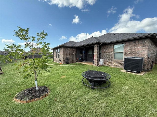 18641 Como Dr, Edmond, OK 73012 - back of house featuring an outdoor fire pit, brick siding, and roof with shingles