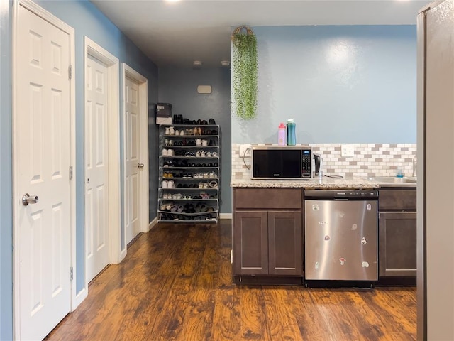 223 SE 53rd St, Oklahoma City, OK 73129 - kitchen with stainless steel dishwasher, dark wood-style floors, decorative backsplash, dark brown cabinets, and light stone counters
