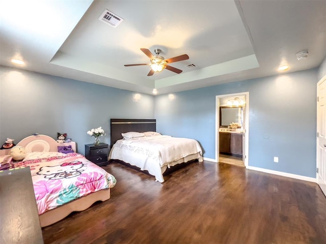 223 SE 53rd St, Oklahoma City, OK 73129 - bedroom featuring a tray ceiling, wood finished floors, a ceiling fan, and ensuite bathroom
