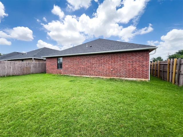 223 SE 53rd St, Oklahoma City, OK 73129 - back of property with a fenced backyard, brick siding, and roof with shingles