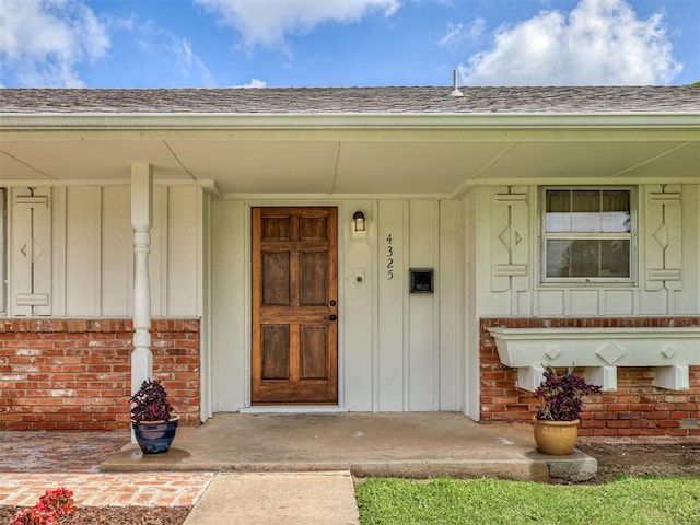 4325 NW 44th St, Oklahoma City, OK 73112 - entrance to property with board and batten siding, a shingled roof, and brick siding