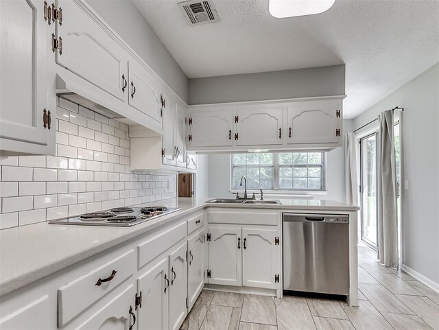4325 NW 44th St, Oklahoma City, OK 73112 - kitchen with stainless steel appliances, white cabinetry, backsplash, a textured ceiling, and light countertops