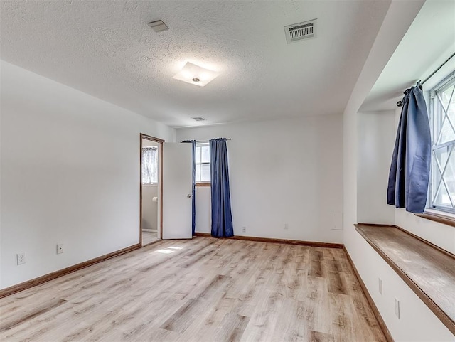4325 NW 44th St, Oklahoma City, OK 73112 - spare room featuring light wood-type flooring and a textured ceiling