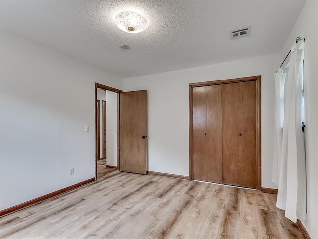 4325 NW 44th St, Oklahoma City, OK 73112 - unfurnished bedroom with light wood finished floors, a closet, and a textured ceiling