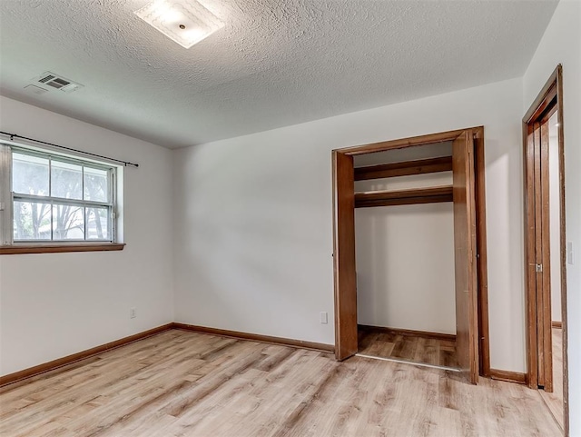 4325 NW 44th St, Oklahoma City, OK 73112 - unfurnished bedroom featuring light wood-style floors, a closet, and a textured ceiling