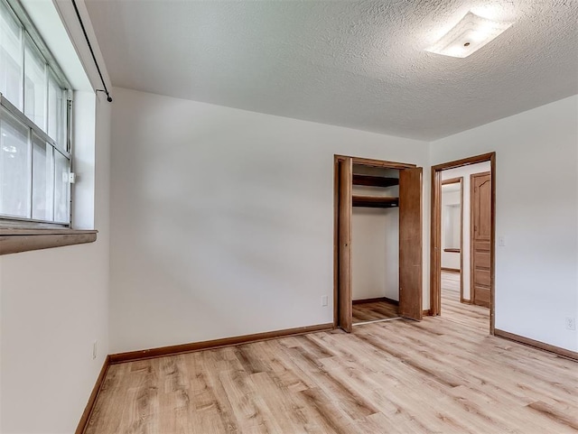 4325 NW 44th St, Oklahoma City, OK 73112 - unfurnished bedroom with light wood-style floors, a closet, and a textured ceiling