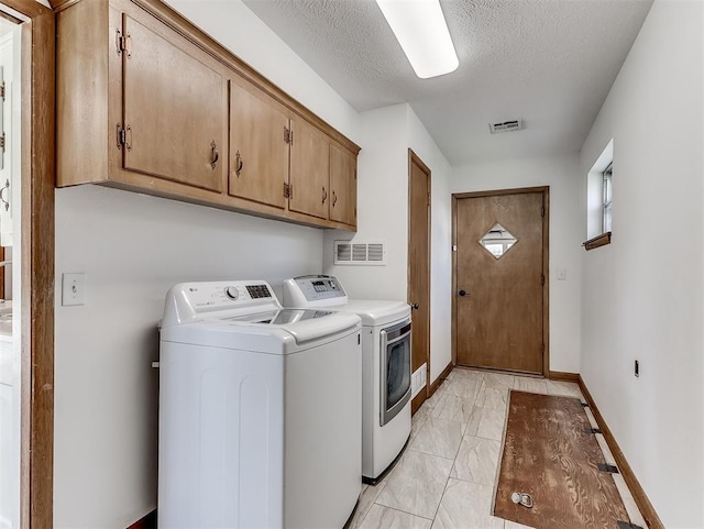 4325 NW 44th St, Oklahoma City, OK 73112 - laundry area with independent washer and dryer, cabinet space, light marble finish floors, and a textured ceiling